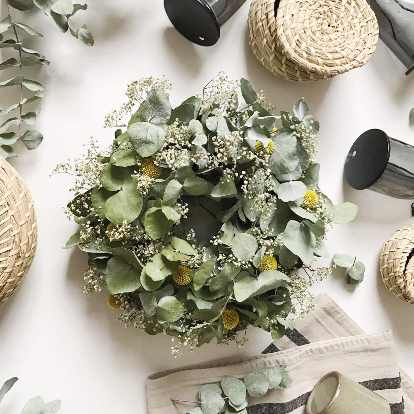 Wreath on a table with leaves and props next to it