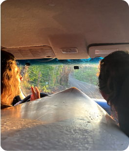 Friends in a car with a surfboard in the backseat