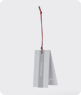 Branded swing tag with copper coloured cord, floating with Antithesis written on the front